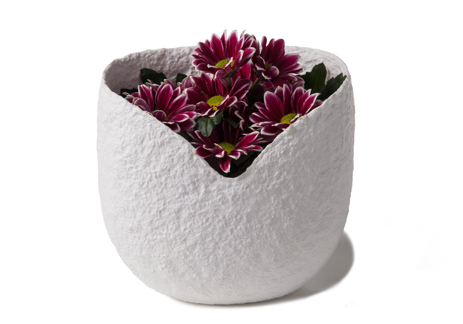 Picture of a white biodegrdable coton fibre cremation urn resembling a Moses basket for children on sale at Muses Design Urns. View with flowers A.